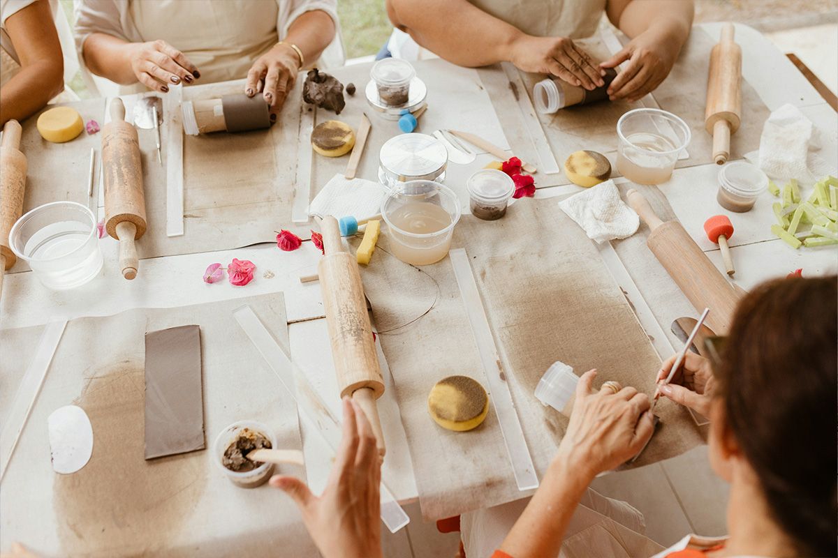 Hands shaping clay at a pottery class